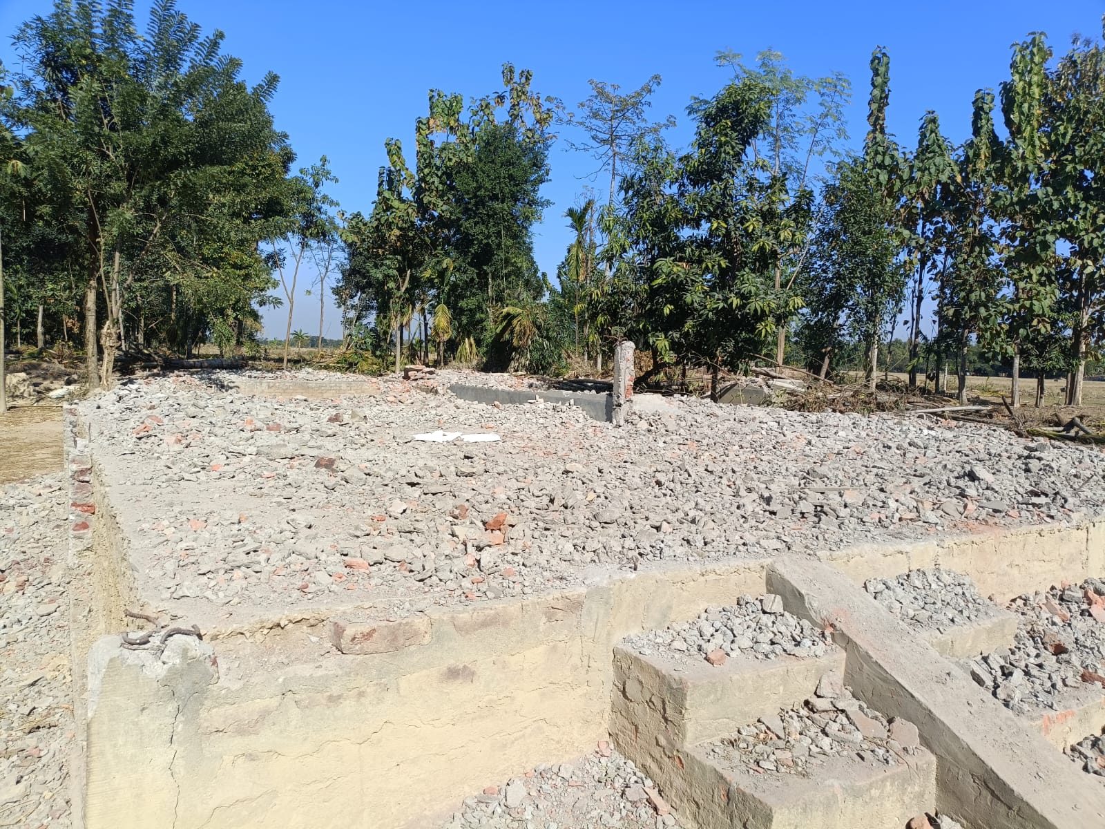 Concrete foundation steps amid rubble where homes were demolished