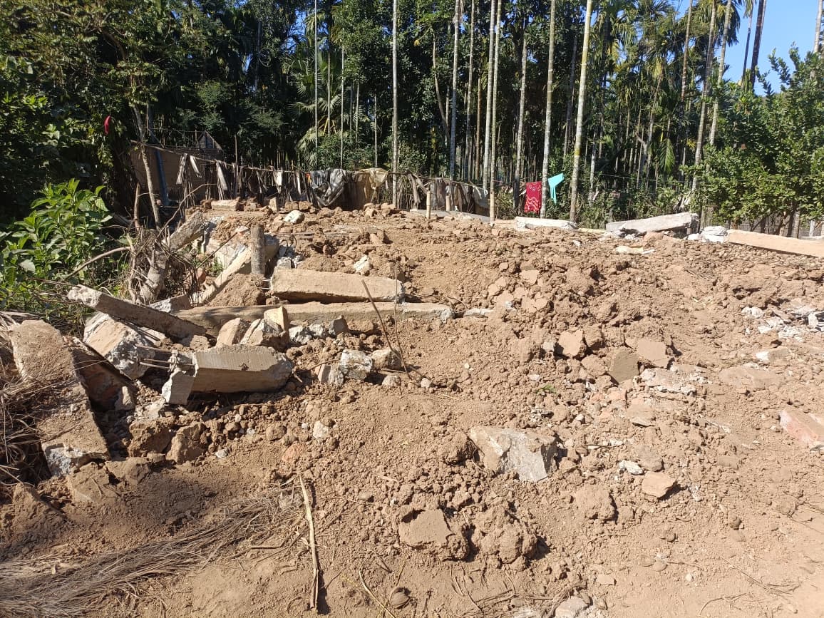 Flattened muddy ground with laundry hanging in the background